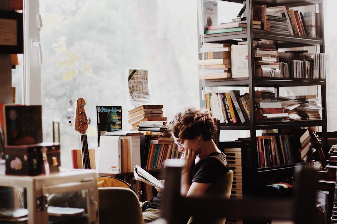 woman reading book sitting beside electronic keyboard woman reading book sitting beside electronic keyboard