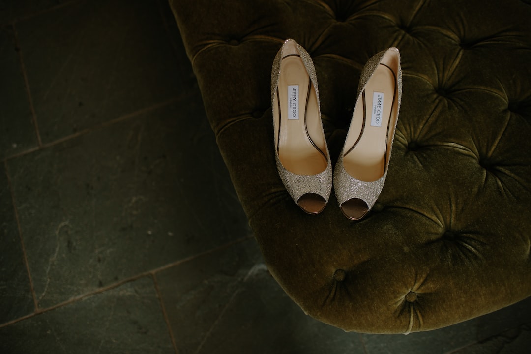 pair of brown gray leather open-toe heeled shoes on tufted mattress pair of brown gray leather open-toe heeled shoes on tufted mattress